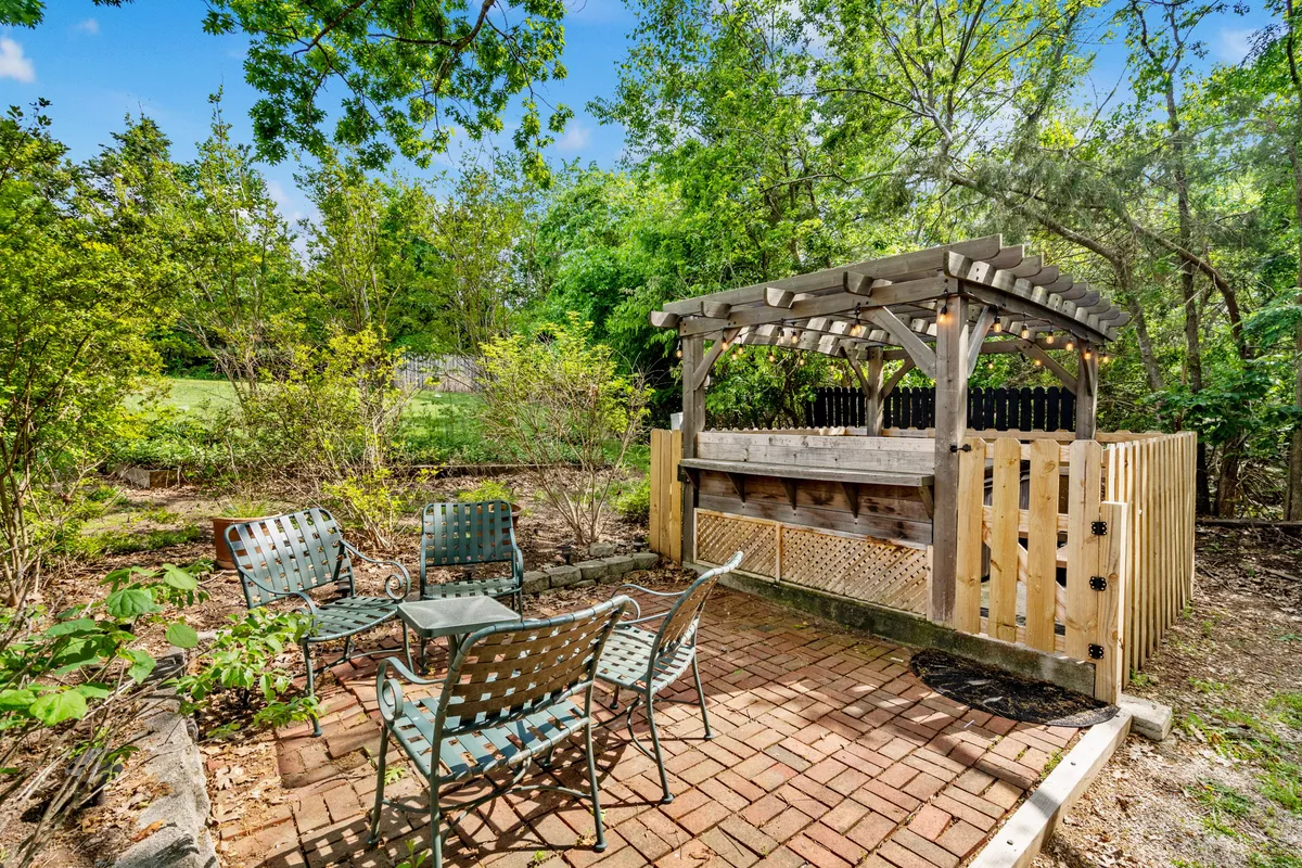 An outdoor bar and seating area surrounded by greenery, suggesting a lively gathering spot for guests to relax, enjoy drinks, or socialize after a day of adventure. The setup is casual yet welcoming, perfect for evenings spent with friends or fellow travelers.