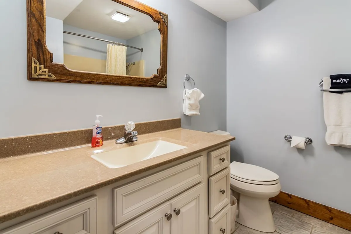 A sparkling clean bathroom with a vanity, sink, mirror, and toilet, designed in an inviting and practical style. The fixtures and finishes highlight a space perfect for personal grooming and relaxation.