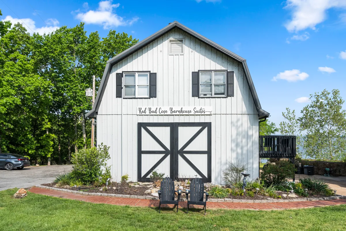 This exterior shot showcases the barn-style architecture of the Barnsuites with well-kept lawn chairs and landscaping. The space invites guests to enjoy the outdoors, host barbecues, and gather for social activities. The presence of outdoor furniture hints at communal games and shared experiences.